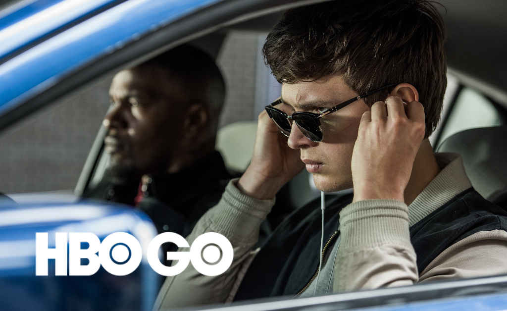 Baby (ANSEL ELGORT) and Bats (JAMIE FOXX) on the way to the post office job with Buddy (JON HAMM) and Darling (EIZA GONZALEZ) as cops pull up next to them in TriStar Pictures' BABY DRIVER.